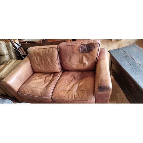 272 - A tan leather two seater sofa, 170 x 95 x 83cm.