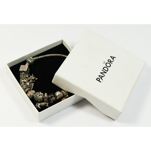 A silver Pandora bracelet with multiple charms, box, 68gm
