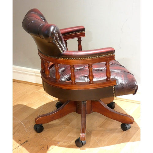 A captain's chair, mahogany frame with padded red wine leather ...