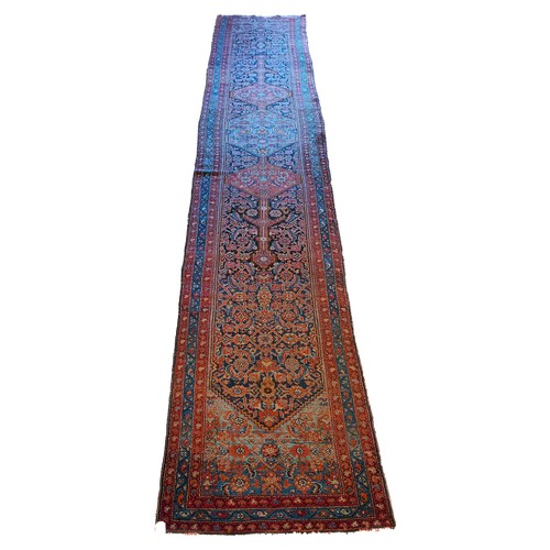 156 - A Persian Heriz long runner, with black, dark blue and red geometric field, 109 x 580cm