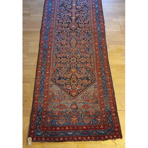 156 - A Persian Heriz long runner, with black, dark blue and red geometric field, 109 x 580cm