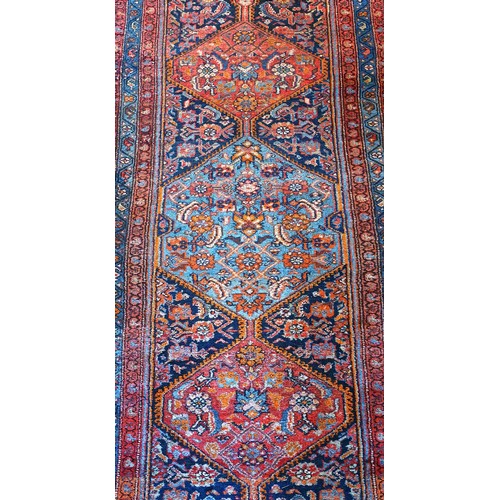 156 - A Persian Heriz long runner, with black, dark blue and red geometric field, 109 x 580cm