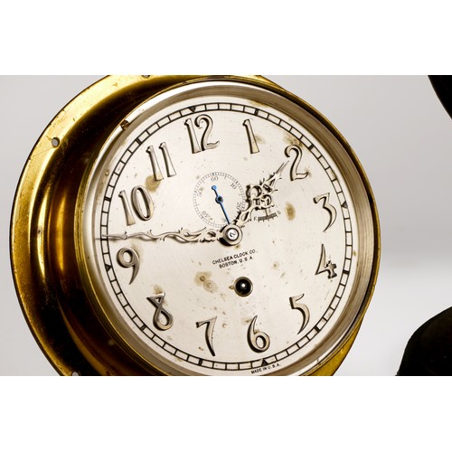 301 - A ships brass bulkhead clock, having manual wind movement, the silvered dial with raised Arabic nume... 