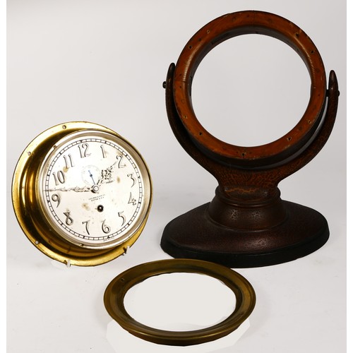 301 - A ships brass bulkhead clock, having manual wind movement, the silvered dial with raised Arabic nume... 