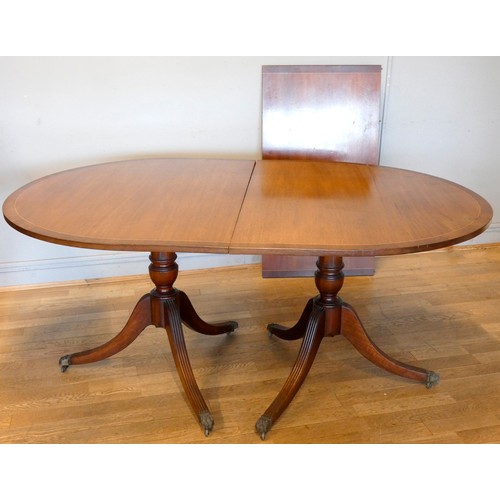 373 - A late 20th century mahogany extending dining table, twin pedestal with single leaf, together with a... 