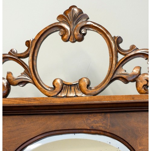 378 - A Victorian mahogany ornate display cabinet, the shaped raised back set with a bevelled oval mirror ... 