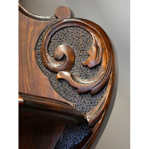 378 - A Victorian mahogany ornate display cabinet, the shaped raised back set with a bevelled oval mirror ... 