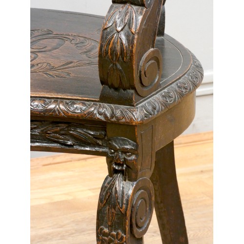 383 - A 19th Century Renaissance Revival carved oak Glastonbury armchair, the shaped back rail carved with... 