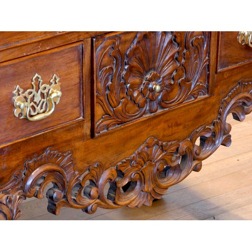 388 - An Indonesian carved hardwood lowboy, the plain top with applied moulded edge over two long and two ... 