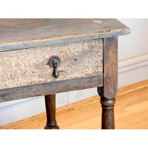 402 - An early 18th century lowboy, the two plank moulded top over a single frieze drawer with brass drop ... 