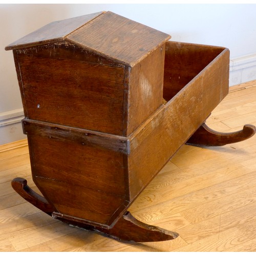 399 - A 19th century oak childs cradle, having arched hood and rockers.
W86, D34, H66cm.