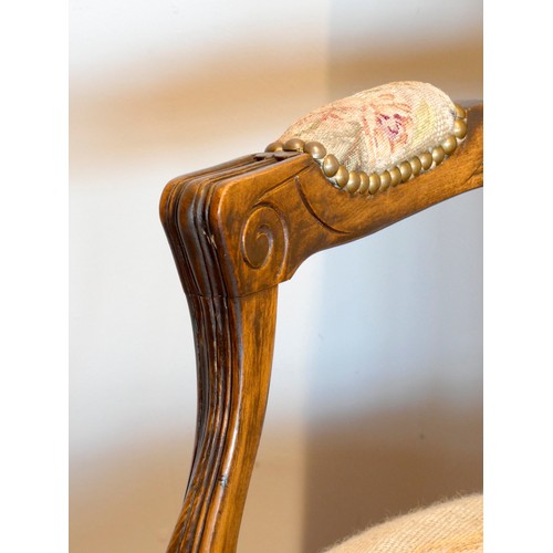 392 - A French Louis XVI style armchair, having carved walnut frame, tapestry upholstered, standing on scr... 