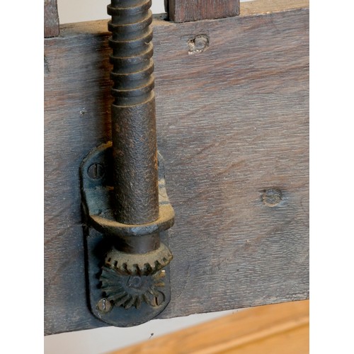 393 - An early 20th century oak studio easel, the 'H' frame with bevel gear mechanism, with shelf and adju... 