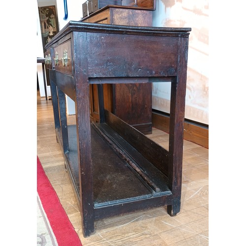 396 - A Georgian oak dresser base, the projecting top fitted with two long drawers having brass loop handl... 