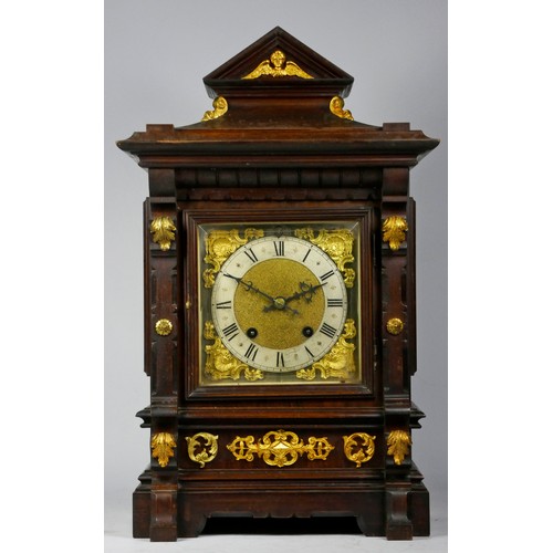 A late 19th early 20th Century German mahogany cased bracket clock, the break-arched dial with silvered chapter ring having Roman numerals framing a matted centre, within scroll spandrels beneath silvered Slow/Fast ring to arch, two two-train movements stamped logo 'R.S.M 6256 16', ting-tang striking on two coiled gongs, with pendulum.
H48, W28, D21cm.