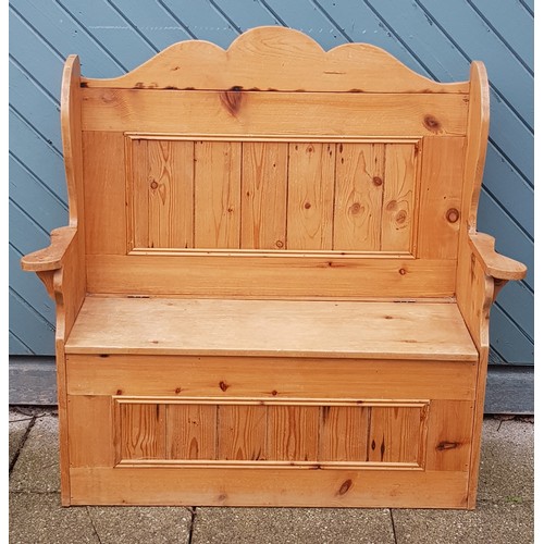 364 - A stripped pine settle, having panelled back and scrolled arms, with hinged cupboard seat, on stile ... 