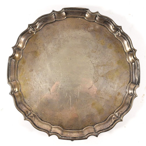 38 - A silver presentation salver, by Baker Bros, Birmingham 1936, with pie crust border, raised on four ... 