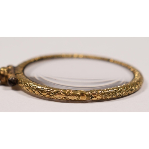 45 - A Georgian gilt metal quizzing glass, with textured coiled snake frame, diameter 35mm.