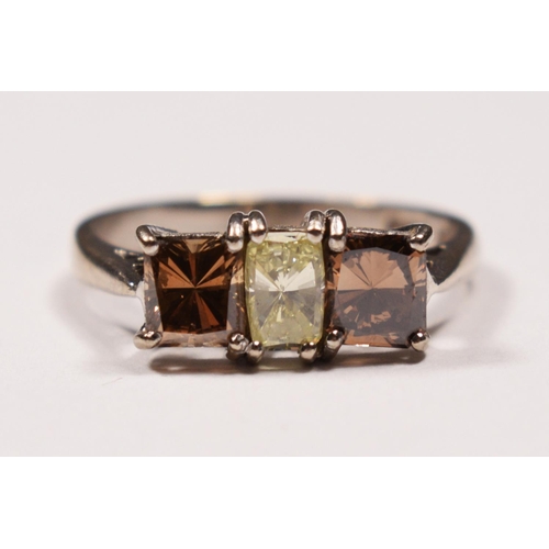 57 - An 18ct white gold three stone diamond ring ring, claw set with a yellow stone of approximately 0.40... 