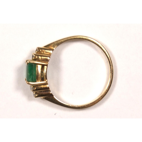 60 - A 14K gold emerald and diamond ring, claw set with an emerald cut stone, 6 x 5mm flanked by single c... 