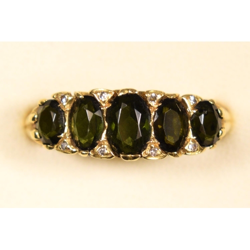 82 - An 18ct gold five stone green tourmaline ring, carved claw set with mixed cut stones, diamond points... 