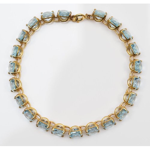 84 - A gold and blue topaz line bracelet, claw set with brilliant cut stones, tested as 9ct gold, silver ... 