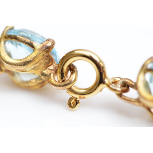 84 - A gold and blue topaz line bracelet, claw set with brilliant cut stones, tested as 9ct gold, silver ... 