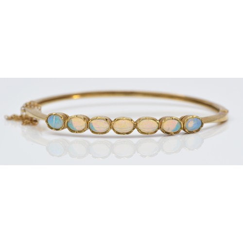 87 - A vintage 9ct gold seven stone opal bracelet, London 1993, collet set with cabochon stones, 56 x 50m... 