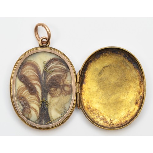 91 - A Victorian gold and black enamel mourning locket, tests as 15ct, opening to reveal an original lock... 