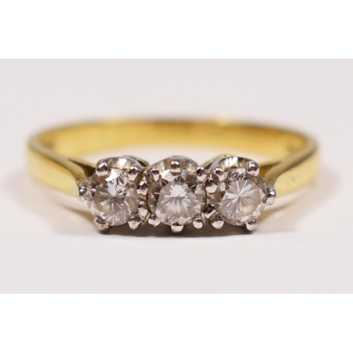 95 - An 18ct gold three stone diamond ring, claw set with brilliant cut stones, London 1986, stated weigh... 