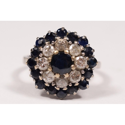 100 - An 18ct white gold sapphire and diamond cluster ring, claw set with brilliant cut stones, diamond we... 