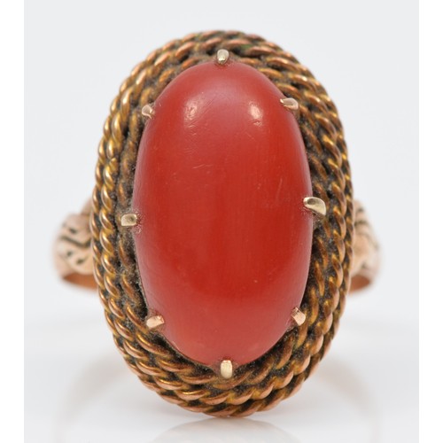 120 - A rose gold and coral dress ring, stamped 18K, the cabochon stone 17 x 9mm, O, 12gm