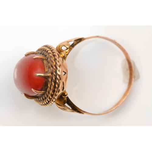 120 - A rose gold and coral dress ring, stamped 18K, the cabochon stone 17 x 9mm, O, 12gm