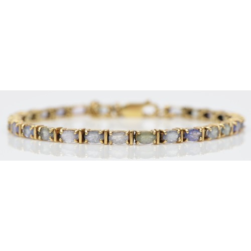 106 - A 9ct gold and multi gemstone line bracelet, claw set with tanzanite, beryl and amethyst, 17.5cm, 9.... 