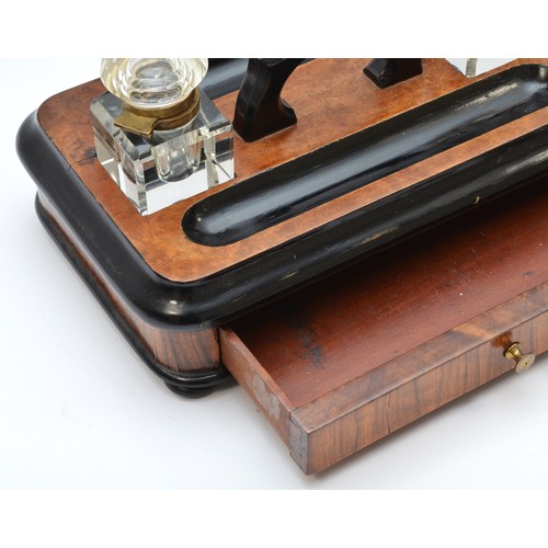 223 - A late Victorian ebonised and walnut double inkstand, with two glass ink bottles, two pen trays and ... 