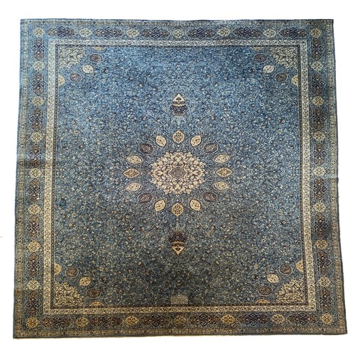 227 - A Persian Kashan style woven wool rug with a floral pattern on a blue ground with triple guard borde... 