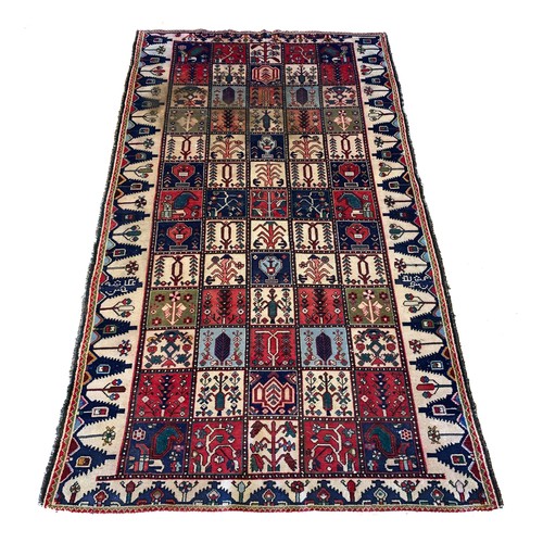 228 - A Persian Bakhtiari woven wool rug, having burgundy and ivory ground with square floral motifs and r... 