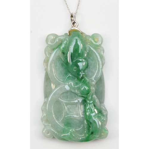 241 - An 18k white gold mounted carved jadeite pendant, single koi carp to one side, two to the other, 45 ... 