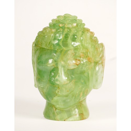 242 - A carved green hardstone Buddha head lamp, mounted on a mahogany stand, 29cm.