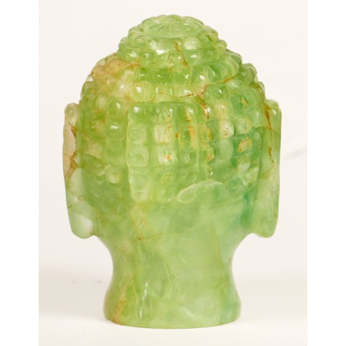 242 - A carved green hardstone Buddha head lamp, mounted on a mahogany stand, 29cm.