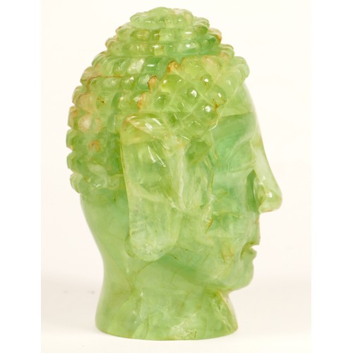 242 - A carved green hardstone Buddha head lamp, mounted on a mahogany stand, 29cm.