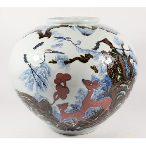 243 - A large Japanese bowl, decorated with cranes above deer amongst trees, character marks to the base, ... 