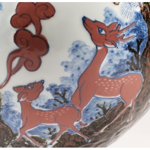 243 - A large Japanese bowl, decorated with cranes above deer amongst trees, character marks to the base, ... 