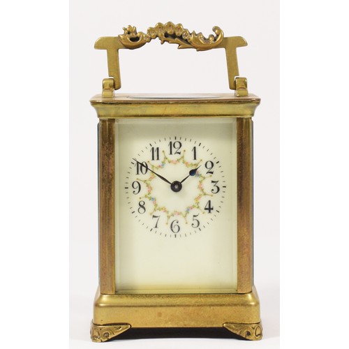 251 - A brass carriage time piece, the off white dial with floral garland, ornate handle and feet, 11.5cm.