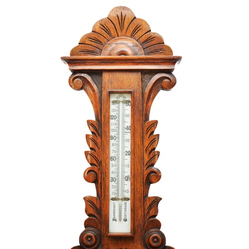 310 - A Victorian carved oak aneroid wheel barometer, with white glass dial and separate thermometer, 88cm