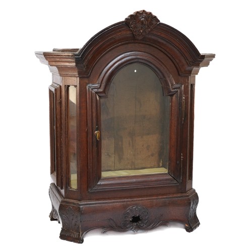 339 - A French oak display cabinet, with arched glazed door, canted glazed panels, raised on a floral carv... 