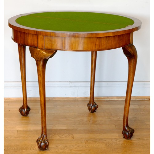 343 - An Edwardian walnut demi-lune fold over games table with baize lined interior, raised on outstretche... 