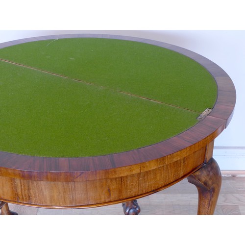 343 - An Edwardian walnut demi-lune fold over games table with baize lined interior, raised on outstretche... 