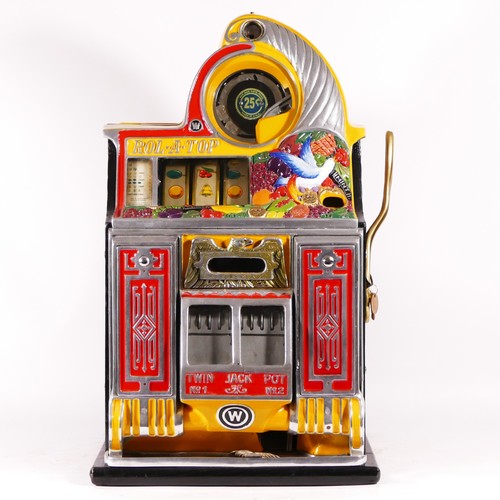 A Watling Rol-A-Top Birds Of Paradise slot machine, one arm bandit, c.1934, restored and working on an American 25 cent coin, wooden case with cast metal cabinet, stamped with Pat No,  hand painted decoration of exotic fruits and a bird above a brass eagle flanked by cast hand painted panels, glazed twin jackpot windows above a Watling logo, 40 x 70 x 37cm, mint vendor with gold award and twin jackpot, pays out, locks, with key.