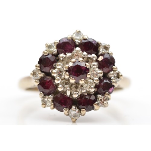 89 - An 18ct white gold ruby and brilliant cut diamond cluster ring, L, 5.6gm